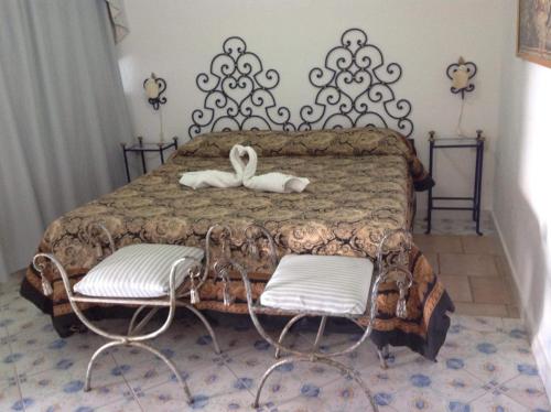 a bedroom with a bed with two white chairs at la guardia in Anacapri