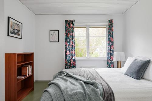 een slaapkamer met een bed en een raam bij Large family home by the water in Östhammar