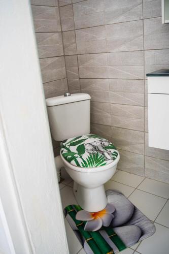 a bathroom with a toilet with a flower design on it at Domaine de la rosa spa privatif in Les Abymes