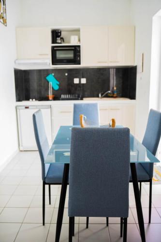 a blue table and chairs in a kitchen at Domaine de la rosa spa privatif in Les Abymes