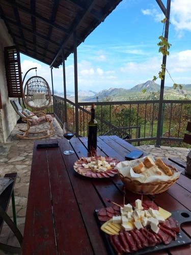 維爾巴札拉的住宿－Banjo Rustic House Lake view，一张野餐桌,包括一瓶葡萄酒和奶酪