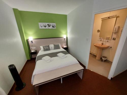 a bedroom with a bed and a bathroom with a sink at Le 120 - Groupe Logis Hotels - Ex Auberge la Terrasse in La Châtaigneraie