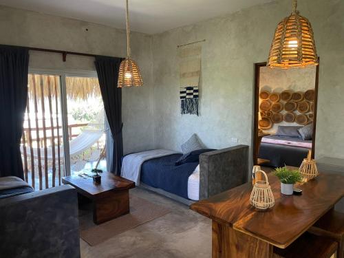 a bedroom with a bed and a table and a couch at Ka´ana Surf in El Paredón Buena Vista