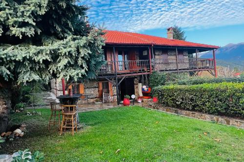 a house with a balcony and a yard at Villa Tzeni Palios Panteleimon in Panteleímon