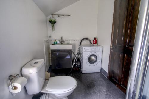 a bathroom with a toilet and a washing machine at #2 Dunkirk by DerBnB, Modern 2 Bedroom City Centre Apartment, Free Parking, WI-FI, Netflix & Within Walking Distance of the City Centre in Derby