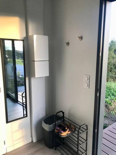 une chambre avec une poubelle à côté d'une fenêtre dans l'établissement Tiny house à la campagne, à Obrechies