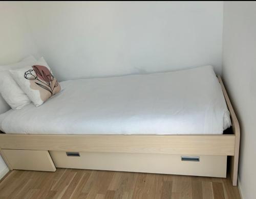 a bed with a wooden frame in a room at New Spacious Two Bedroom Center with Parking, near Public Transport in Luxembourg