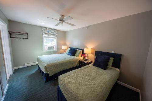 a bedroom with two beds and a ceiling fan at Inn by the River in The Forks