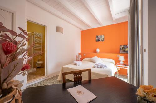 una camera da letto con pareti arancioni, un letto e un tavolo di Villa Clori a Salice Salentino