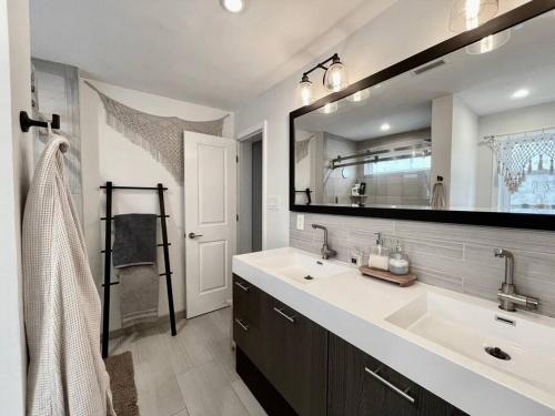 a bathroom with a sink and a large mirror at Perfect WFH Fishtown Townhouse with Private Patio in Philadelphia