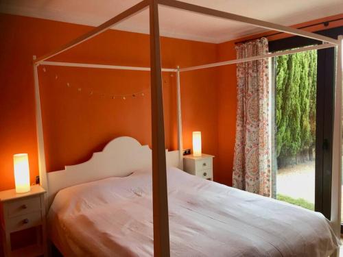 ein Schlafzimmer mit einem Himmelbett und einem Fenster in der Unterkunft Schöne meernahe Villa mit Pool+Grill, Nähe Artà in Colònia de Sant Pere
