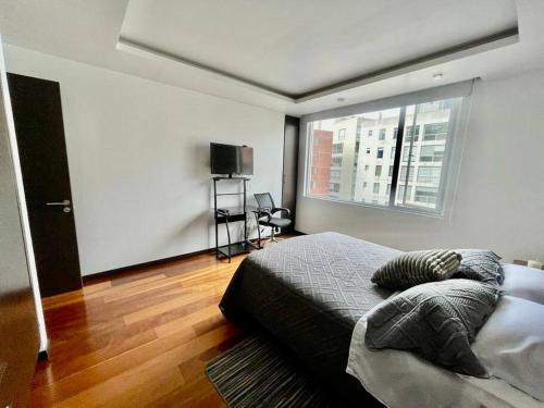 um quarto com uma cama e uma grande janela em Edificio Norland zona privilegiada de La Carolina em Quito