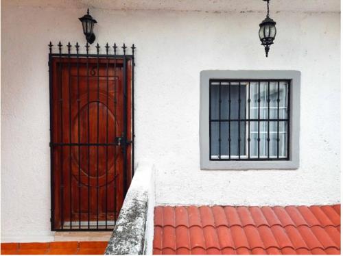 een gebouw met een rode deur en een raam bij Anana Coliving in Playa del Carmen