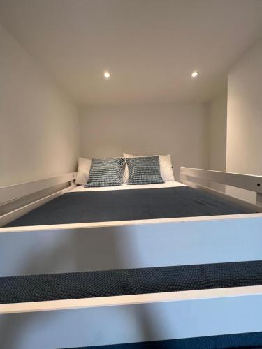a large bed in a room with two pillows on it at Amazing One Bed Flat West Hampstead in London
