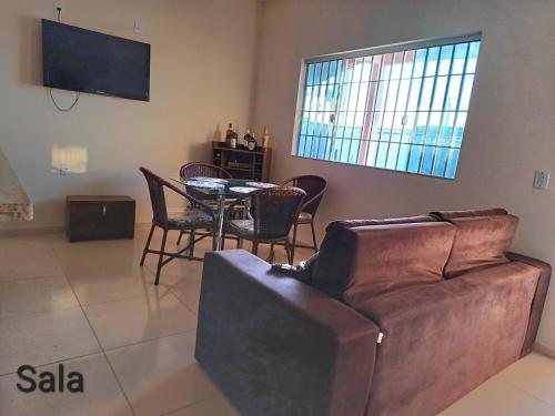 a living room with a couch and a table with chairs at Paraíso de Santa Cruz in Santa Cruz Cabrália