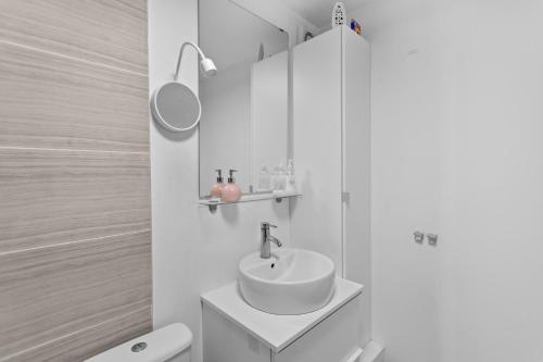 a white bathroom with a sink and a toilet at Cozy 2 Bed Apartment Close to Excel, 02, & London City Airport! in London