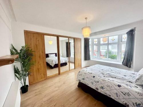 1 dormitorio con cama y ventana grande en 4 Bed house in Daneby Road,SE6, en Catford