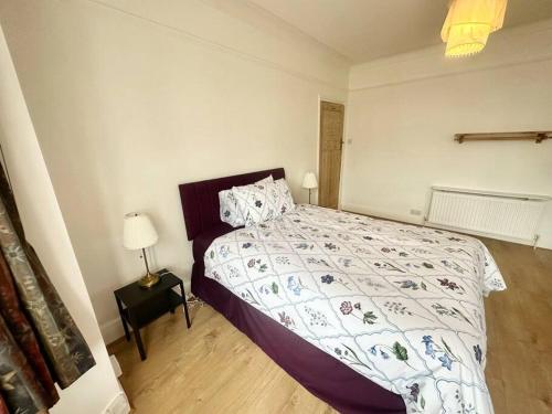 a bedroom with a bed with a comforter on it at 4 Bed house in Daneby Road,SE6 in Catford