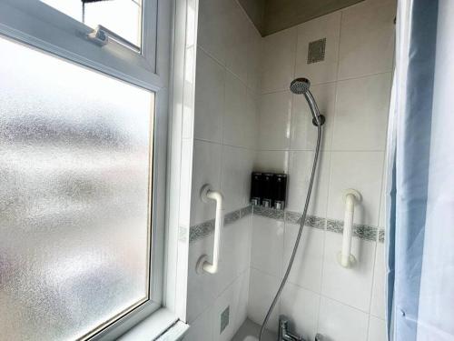 a shower in a bathroom with a window at 4 Bed house in Daneby Road,SE6 in Catford