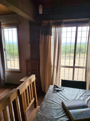 um quarto com uma cama e uma grande janela em Chalet de Montaña Luna de Valle em Valle Hermoso