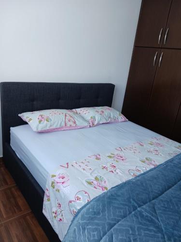 a bed with a black headboard and pink flowers on it at 2 bedroom apartment in Nicosia