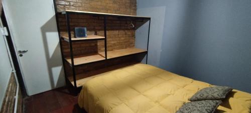 ein kleines Schlafzimmer mit einem Bett und einem Bücherregal in der Unterkunft Casa Céntrica para 7 personas Estacionamiento Gratuito in Mendoza