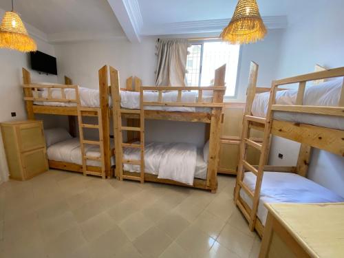 a room with four bunk beds in a room at West coast surf house in Imsouane