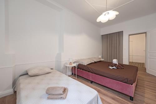 une chambre avec deux lits, une table et une lampe dans l'établissement Le Louis XVI - Majestueux Appart Centre Ville, à Carcassonne