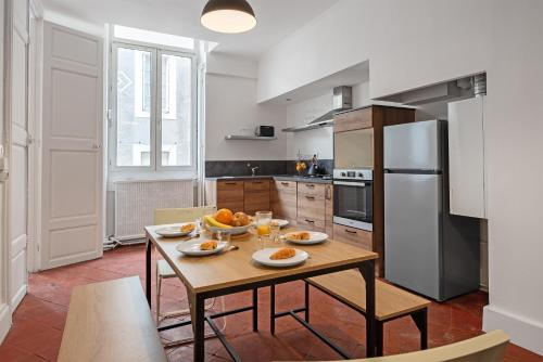une cuisine avec une table et des assiettes de nourriture dans l'établissement Le Louis XVI - Majestueux Appart Centre Ville, à Carcassonne