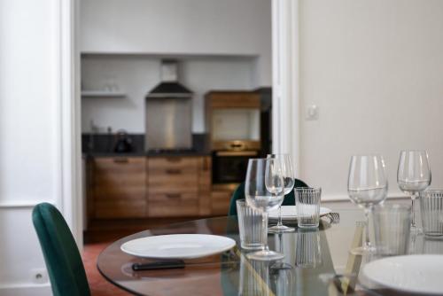 une table de salle à manger avec des verres à vin dessus dans l'établissement Le Louis XVI - Majestueux Appart Centre Ville, à Carcassonne