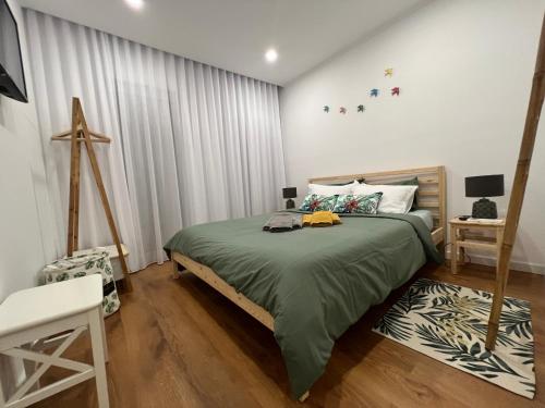 a bedroom with a bed with a green blanket at Urban 41 Guest House in Ponta Delgada