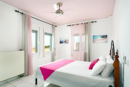 een slaapkamer met een bed met roze en witte kussens bij Family big apartment with sea view 2-5 people in Atsipopoulo