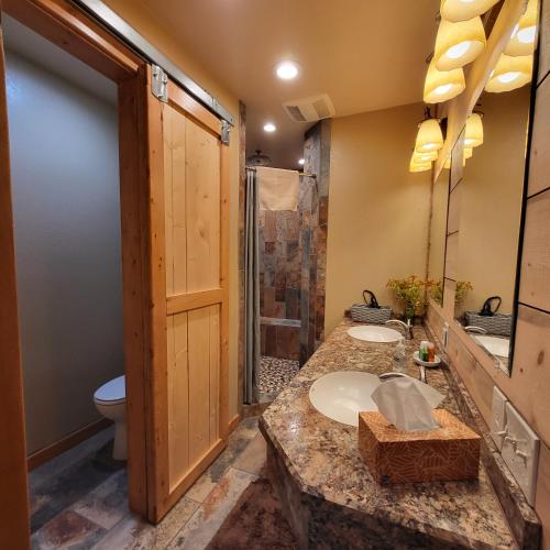 uma casa de banho com 2 lavatórios e um chuveiro em BuffaloPeaks Lodge em Buena Vista