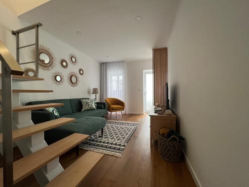 a living room with a green couch and a staircase at Urban 41 Guest House in Ponta Delgada