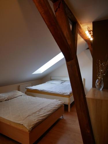 two beds in a attic room with a ceiling at Lipno -1 Apartmány in Lipno nad Vltavou