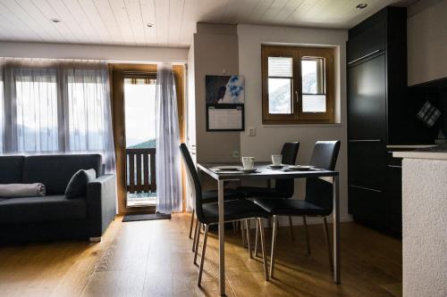 a living room with a table with chairs and a couch at Moderne 2-Zimmer-Wohnung in Albinen mit Aussicht in Albinen