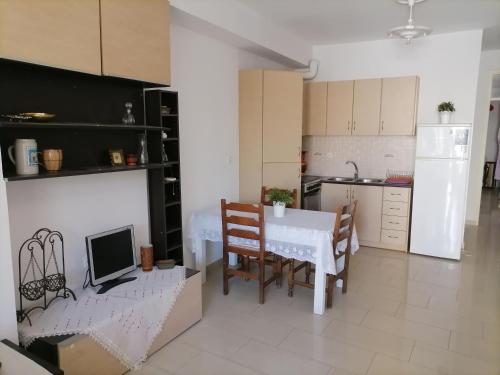 a kitchen with a table and a white table and chairs at PERGAMOS APARTMENTS in Mytilene