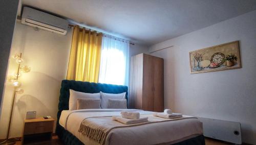 a bedroom with a bed with two towels on it at Soko City Center & Parking Free in Soko Banja