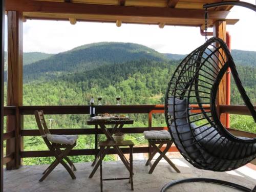 una silla de ratán sentada en un porche con una mesa en Fairytale Stone House, en Karpenisi