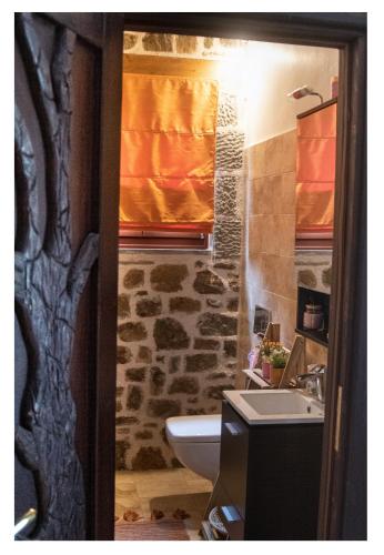 a bathroom with a sink and a toilet and a window at Fairytale Stone House in Karpenisi