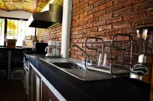 um balcão de cozinha com um lavatório e uma parede de tijolos em CASAS MÉXICO em Macuspana