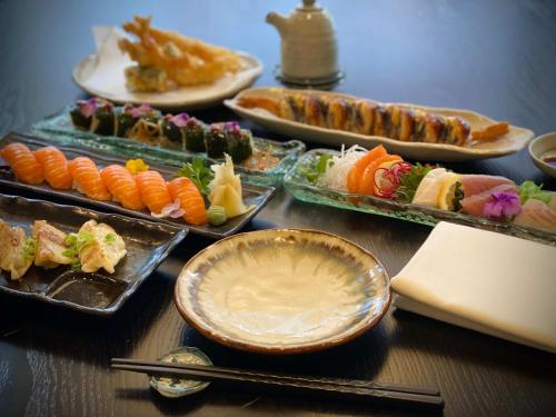 Kyoto Rooms Winchester في وِنشستير: طاولة مليئة بأطباق السوشي والأطعمة الأخرى