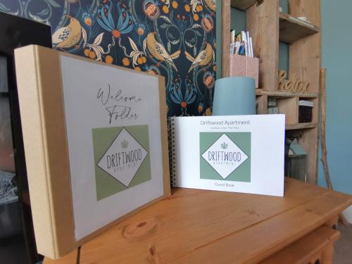 a table with two pictures and a vase on it at Driftwood Apartment in Saltburn-by-the-Sea