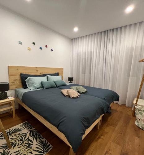 a bedroom with a large bed with blue sheets at Urban 41 Guest House in Ponta Delgada
