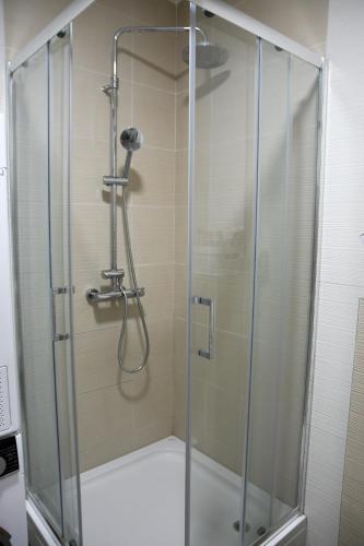 una ducha con puerta de cristal en un baño en New Formula, en Sarajevo