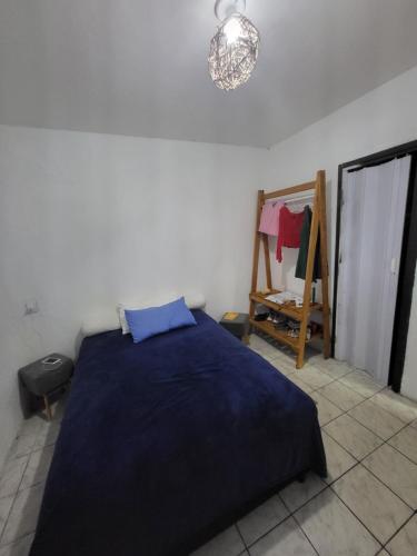 1 dormitorio con cama azul y espejo en Apto 014, en Caucaia