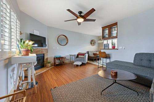 a living room with a blue couch and a ceiling fan at Ocean Beach Pier Condo in San Diego