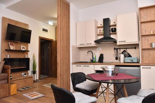 eine Küche und ein Wohnzimmer mit einem Tisch und Stühlen in der Unterkunft Start Apartments LUX KOPAONIK in Kopaonik