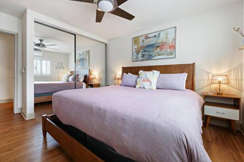 a bedroom with a large bed and a mirror at Ocean Beach Pier Condo in San Diego
