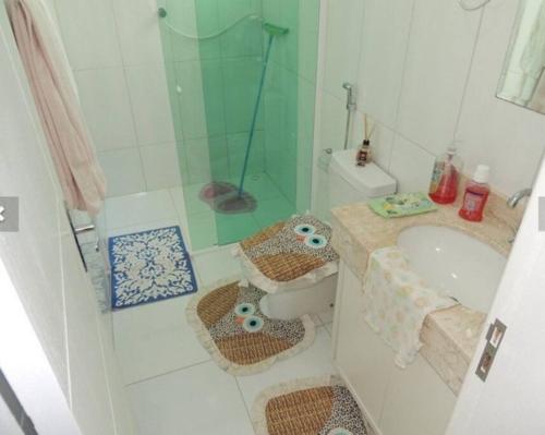 y baño con ducha, lavabo y aseo. en Sobrado super lindo a duas quadras praia., en Guaratuba